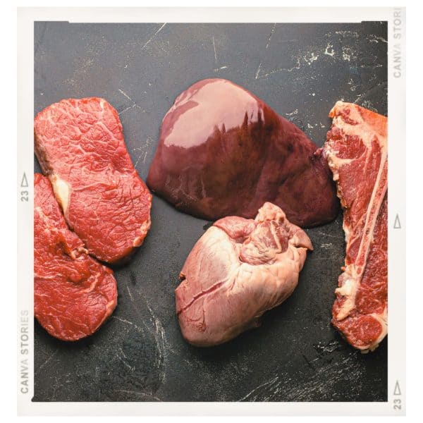 Fresh raw liver and heart on a wooden cutting board, rich in nutrients for a natural canine diet.